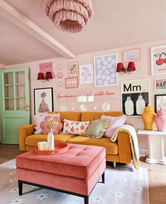 a pretty dopamine decor living room with blush walls and a ceiling, a yellow sofa, a pink ottoman, a bright gallery wall and a pink chandelier