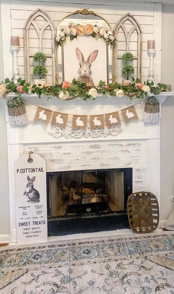 a pretty rustic Easter mantel with a burlap banner, baskets, greenery and faux bloom garlands, a bunny artwork, some greenery topiaries and candles