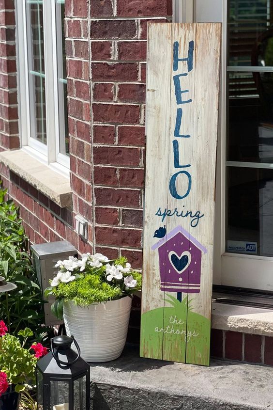 a pretty simple spring sign with painted birds, a bird house and letters is a lovely idea for a farmhouse porch