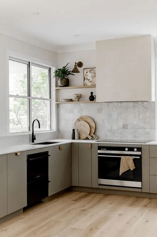 a refined modern kitchen with sleek grey cabinets, a Zellige tile backsplash, a hood and open shelves, black fixtures