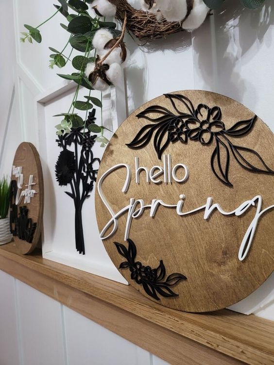 a round spring sign with calligraphy and flowers is a cool idea for spring mantels and console tables