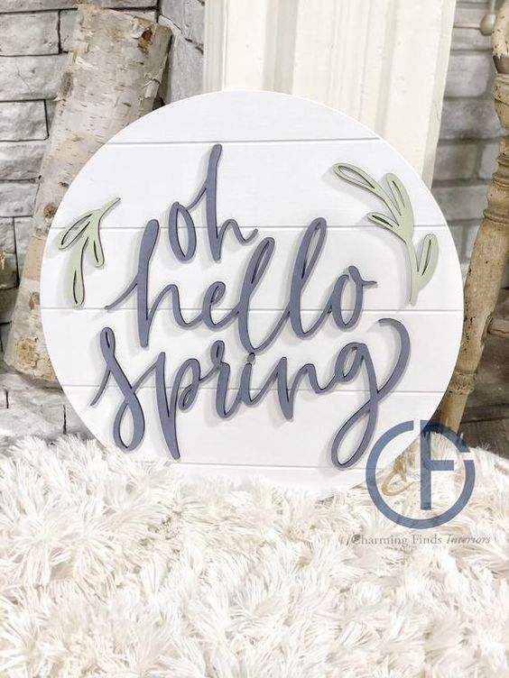 a round spring sign with calligraphy and leaves is a cool idea for spring decor, it will fit a modern space