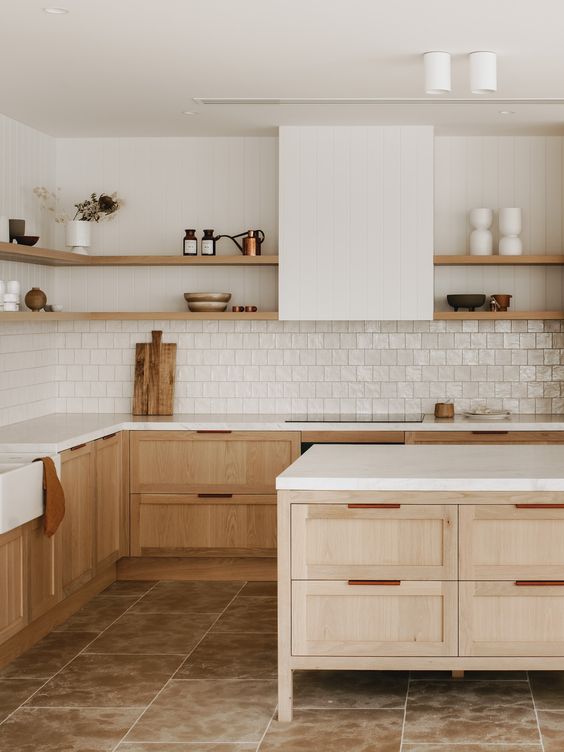 a serene kitchen with stained cabinets and a kitchen island, white countertops, a square Zellige tile backsplash and a white hood