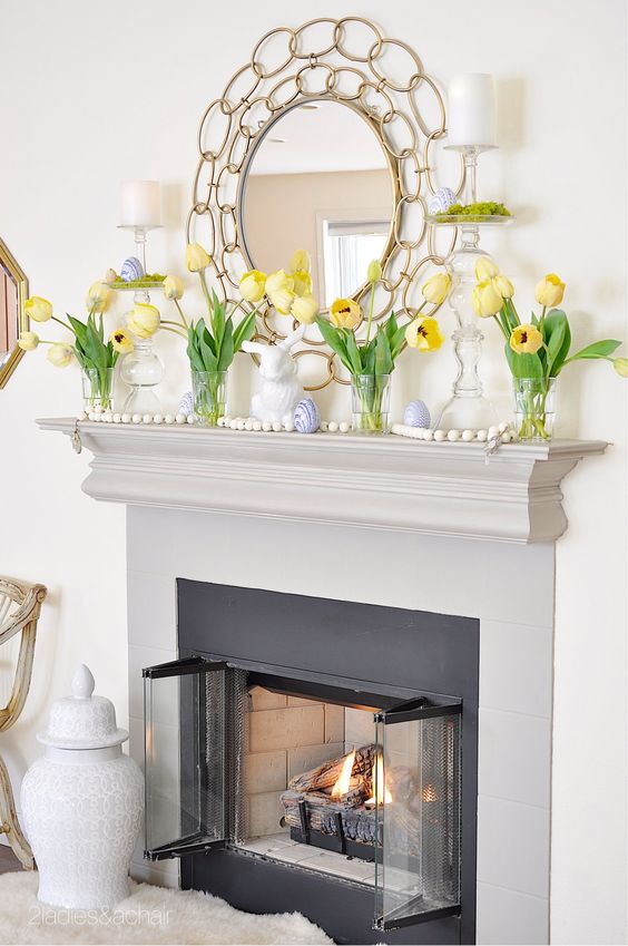 a simple Easter mantel with yellow tulips, bunnies, blue marble eggs is a cool solution and you can recreate all this easily