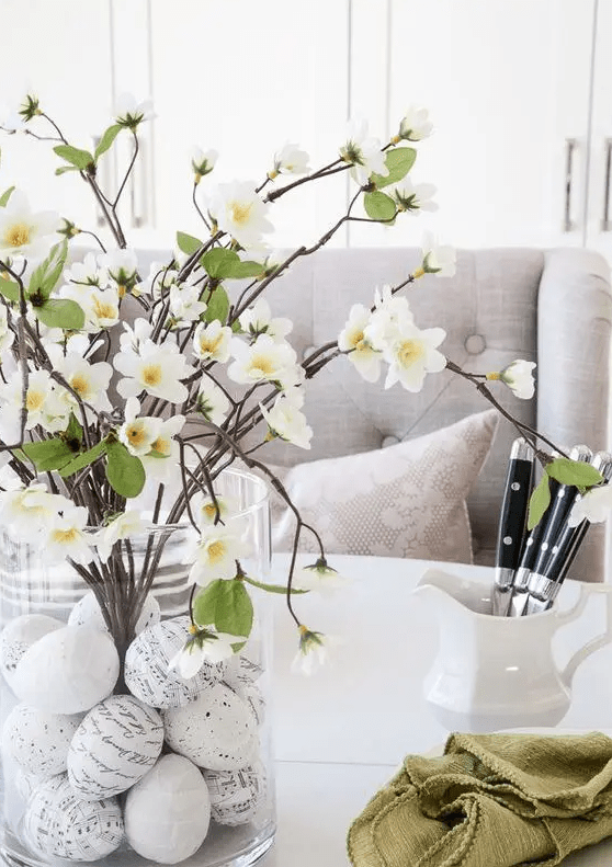 a spring centerpiece of a vase, with handwritten eggs, blooming branches is a classic centerpiece idea for spring
