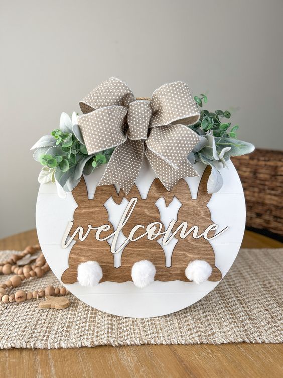 a spring sign with bunnies, calligraphy, a bow and faux greenery and leaves is a lovely idea for spring or Easter