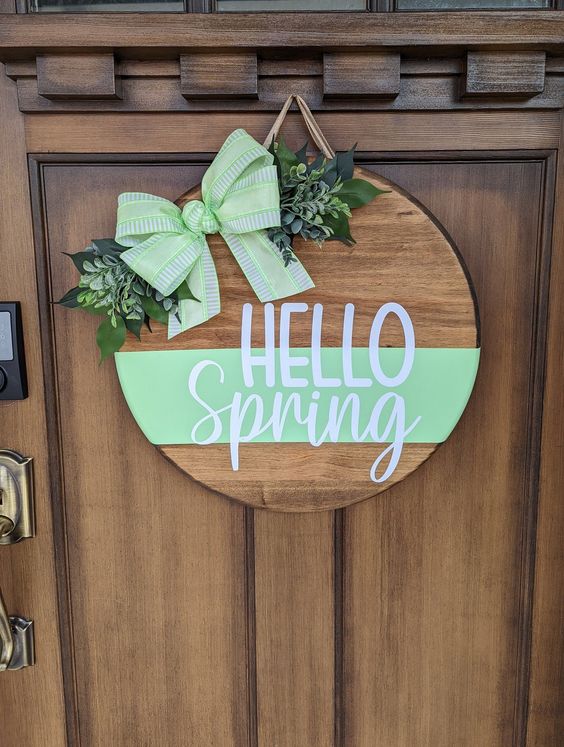 a spring sign with mint green touches, letters, a mint bow and faux greenery is a cool alternative to a spring wreath