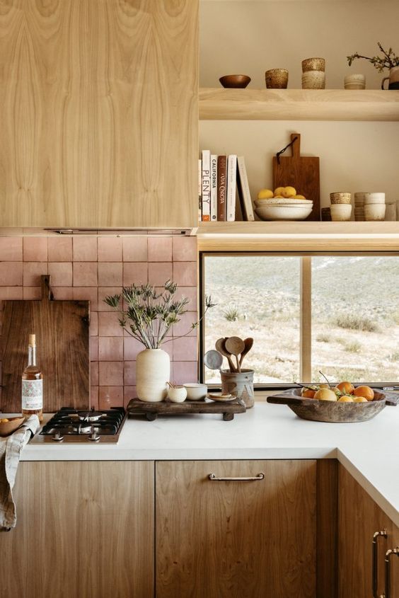 a stained kitchen with white countertops, a pink Zellige tile backsplash, a window and open shelves over it