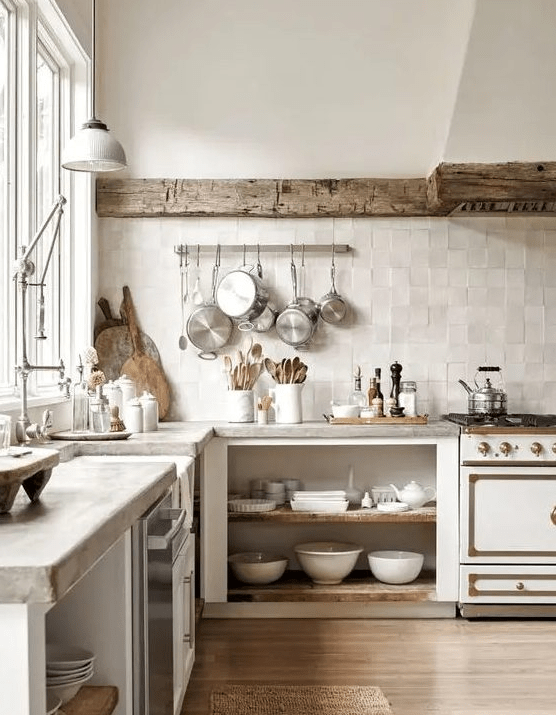 A wabi sabi kitchen with open cabinetry, a reclaimed wooden beam covering the hood, concrete countertops and a neutral zellige tile backsplash