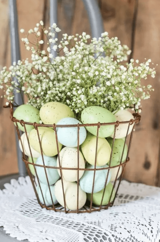 a wire basket with pastel eggs and gypsophilia on top is a lovely spring centerpiece or decoration to rock