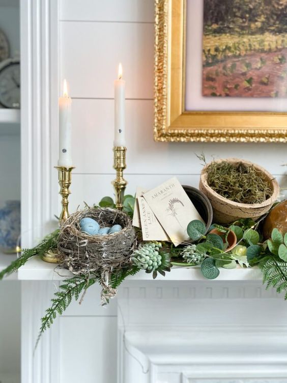 a woodland Easter mantel with greenery, lights, a faux nest with blue eggs, candles, moss in a planter is fab