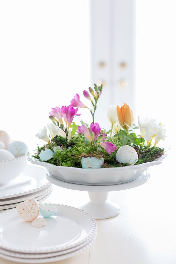 an Easter centerpiece of a bowl with moss, egg shells and bright blooms is amazing for spring and Easter