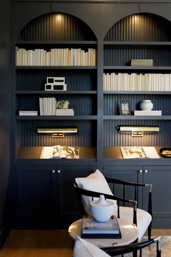 elegant black arched bookcases with fluted backing and lights are a very elegant and chic solution