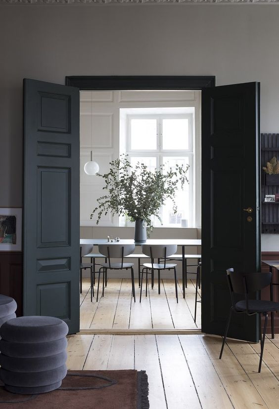 elegant black doors add interest and contrast to the space making it cooler, as the space is neutral itself and lacks contrast