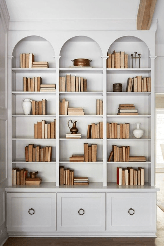 lovely off-white arched bookcases with cabinets and ring pulls are amazing for any space, to add a chic touch to it