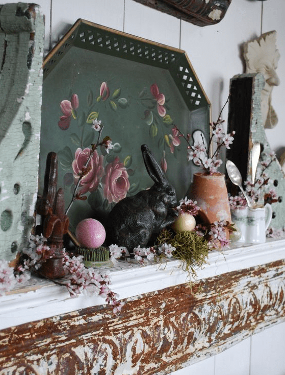 vintage spring mantel decor with a tray with art, some faux blooms and greenery, fake eggs and tableware