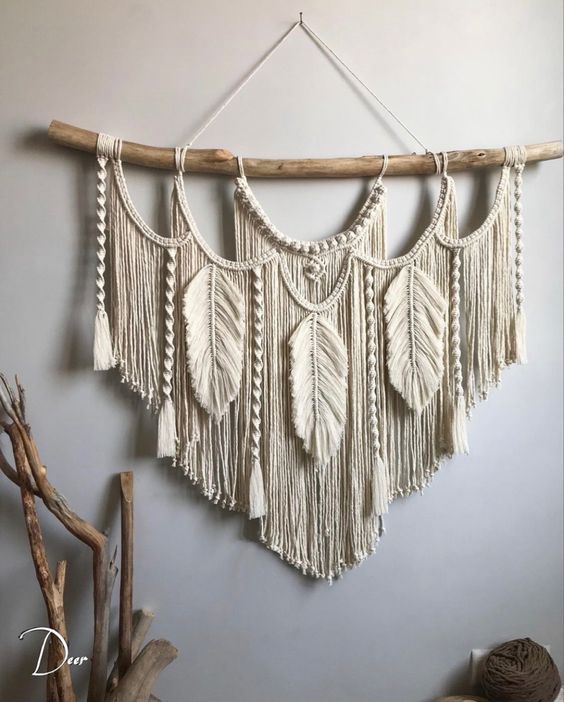 a beautiful neutral macrame with tassels and yarn leaves is a lovely boho decoration for any space
