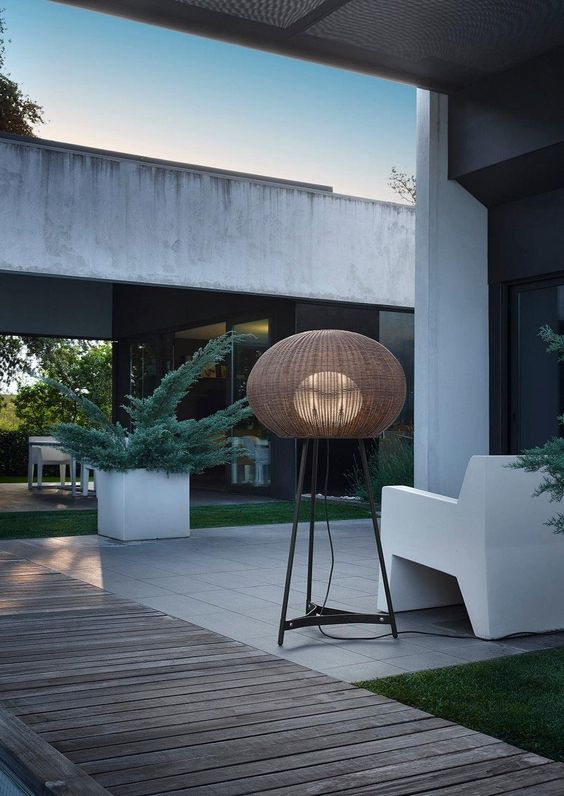 a beautiful outdoor floor lamp with a wicker lampshade and stable legs is a cool idea for a modern or contemporary terrace