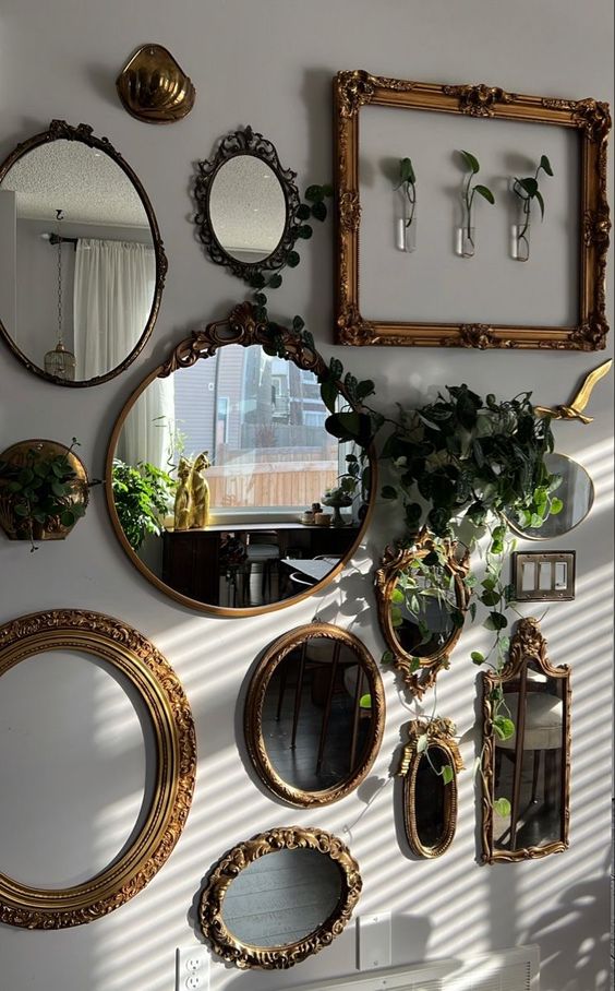 a blank wall done with a mirror gallery wall, with empty frames, greenery and some vases on the wall is amazing