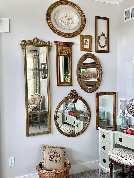 a blank wall with a gallery wall of mirrors in refined and chic gold frames is a cool and chic idea for a refined look