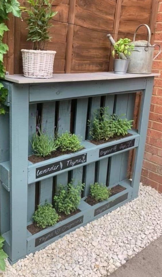 A blue pallet garden with herbs planted and chalkboard stickers is a lovely cottage inspired space decoration