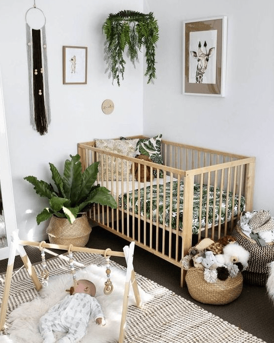 a boho nursery with potted greenery, macrame, wicker baskets and a printed rug