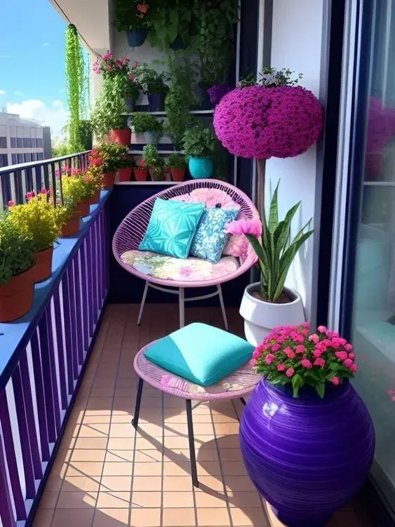 a bold balcony with violet railing, a pink chair and a stool, blue pillows, potted blooms and greenery