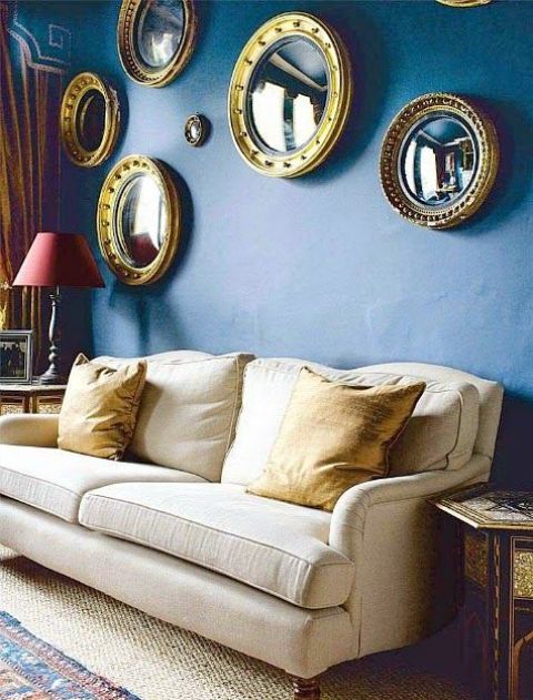 a bold blue wall with a gallery wall of round mirrors in matching frames is amazing for a chic and cool idea