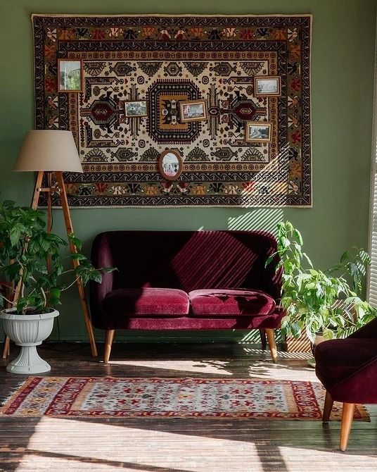 a bold boho rug with some art echoes with the burgundy velvet furniture of the space