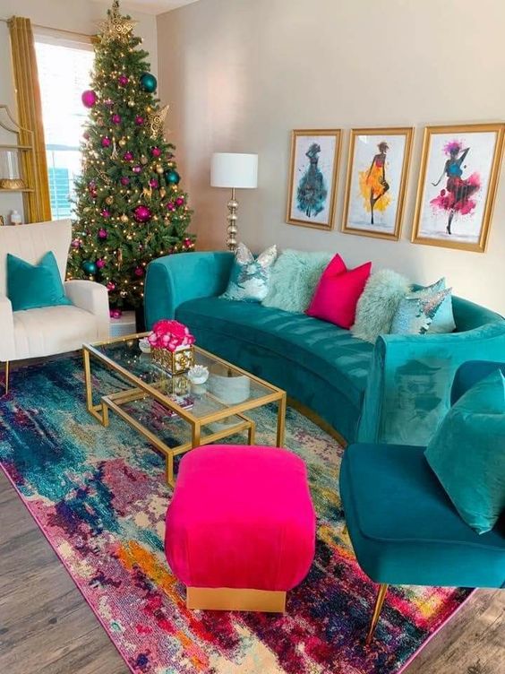 a bold living room with an emerald sofa and chair, a fuchsia pouf and pillow, a bold rug and a Christmas tree