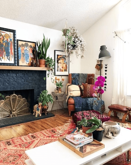 a bright eclectic living room with folksy rugs and blankets, potted greenery and blooms, lamps and bold artworks