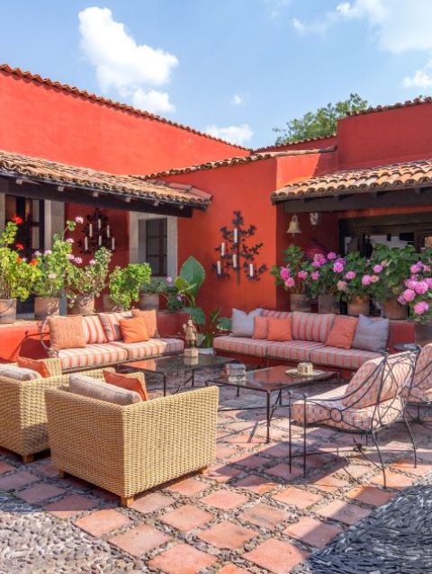 a bright terrace with sofas and colorful cushions and pillows, printed chairs, wicker chairs with pillows