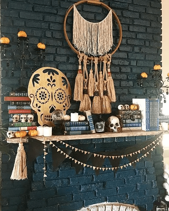 a cool mantel with a boho tassel dream catcher, a sugar skull artwork, a black bunting and some little skulls