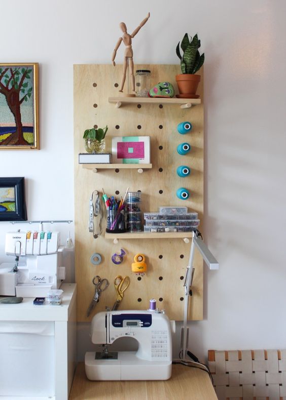 a craft space styled with a pegboard, with shelves and hookd sfor storage is a smart and cool idea
