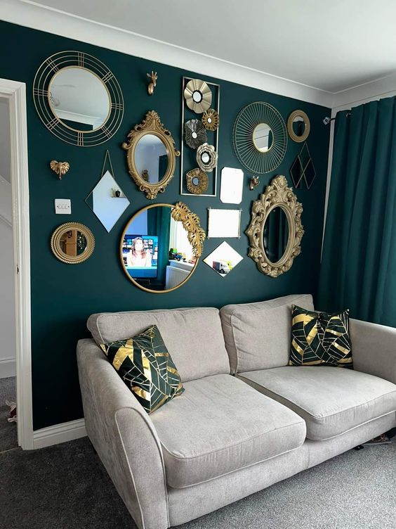 a dark green wall and curtains plus a gallery wall of chic mirrors in gold frames and with godl details create a very sophisticated look