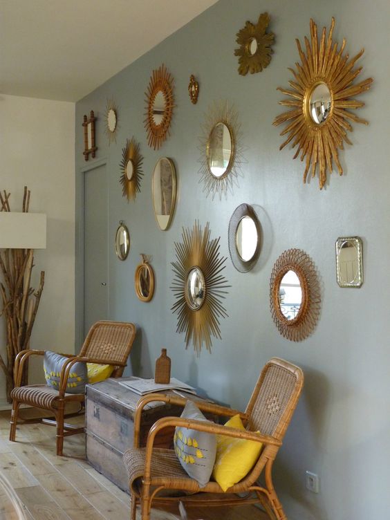 a dove grey wall, a gallery wall of mirrors in various gold and woven frames are a cool and refined combo for many spaces