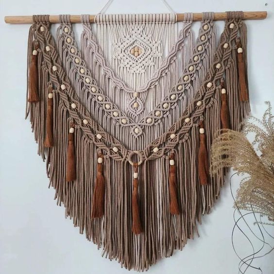 A fantastic beige macrame with beads and rust colored tassels will add both texture and color to the room