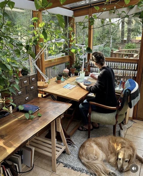a garden home office with desks, a file cabinet, a chair, some rugs and lots of greenery covering the walls and even ceiling