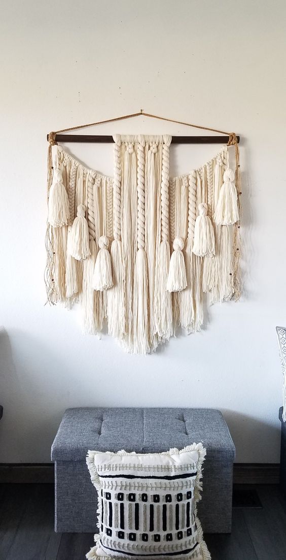 a gorgeous neutral macrame with large tassels and twisted braids is a lovely solution for a boho space