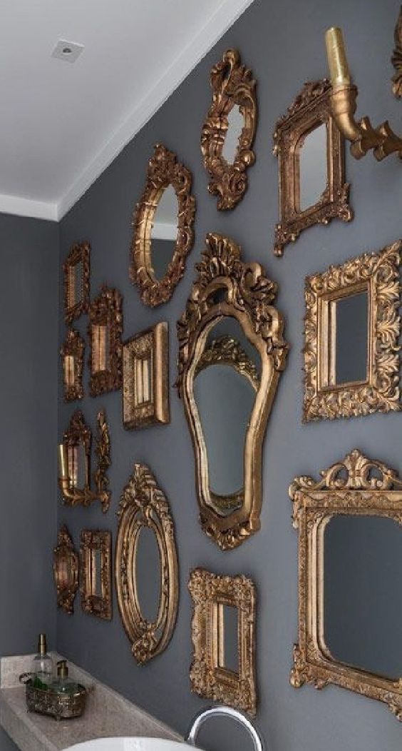 a grey wall with a mirror gallery wall with refined gold frames is a lovely idea for a refined space
