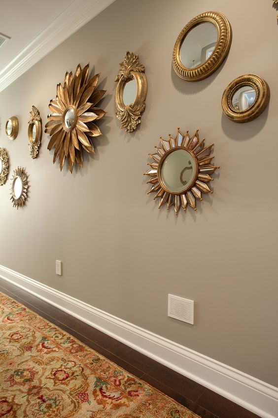 a grey wall with a spectacular mirror gallery wall in gorgeous gold frames looks very refined and chic