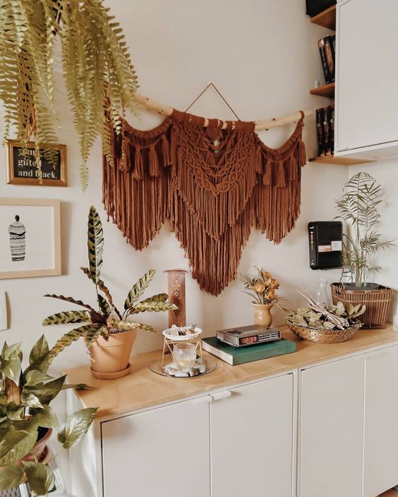 A lovely rust colored macrame hanging on a driftwood branch is a stylish and cool decoration