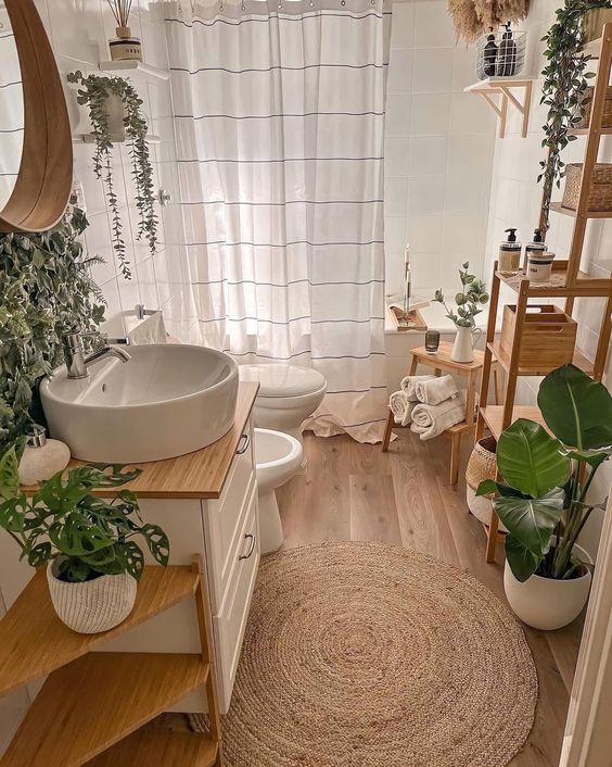 a modern boho bathroom with stained furniture, a jute rug and potted greenery is chic
