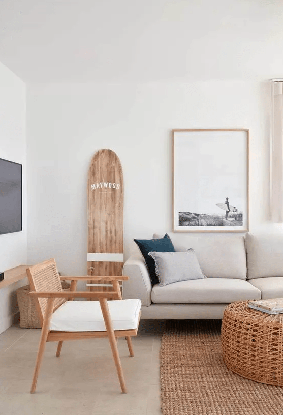 a modern coastal living room with neutral seating furniture, a jute rug, a coffee table, some artwork and minimal decor
