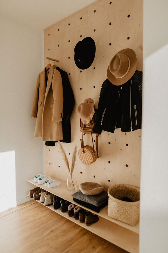 a modern entryway done with open shelves and a pegboard, with hooks and a basket provides a lot of storage space and looks nice