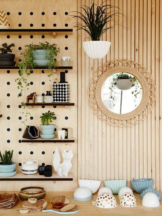 a modern stained wall with planks and a pegboard,w ith shelves, various decor and potted plants is a lovely accenting wall for any room