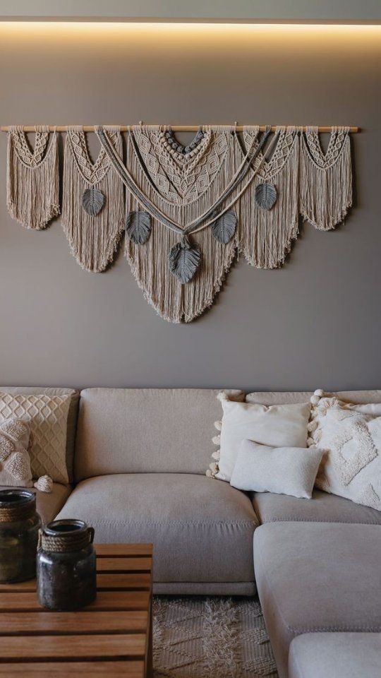 a neutral and complicated macrame accented with grey yarn leaves is a bold and lovely decoration for a boho room