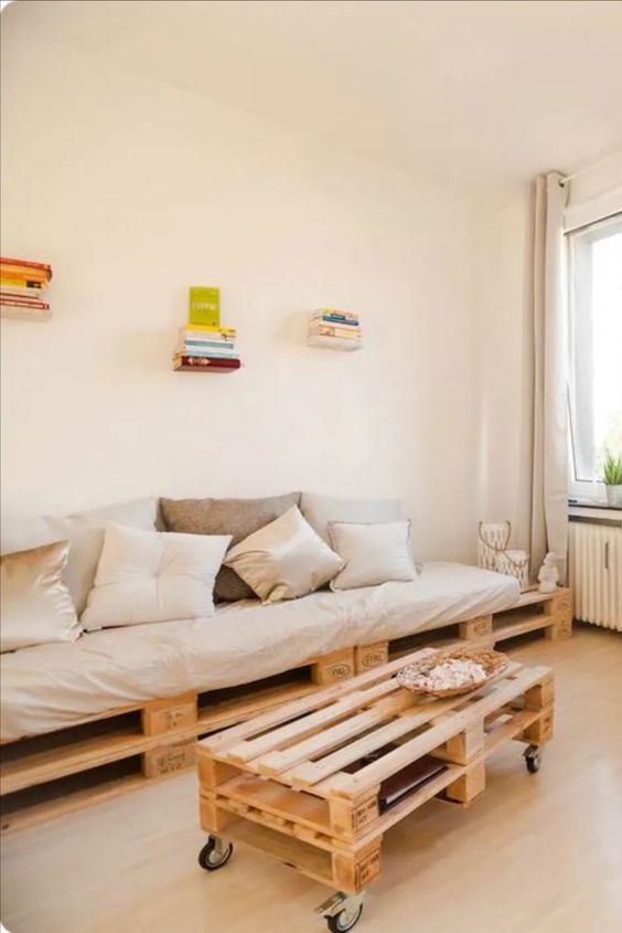 a neutral living room with a pallet sofa and coffee table, some books and decor is a cool and lovely space