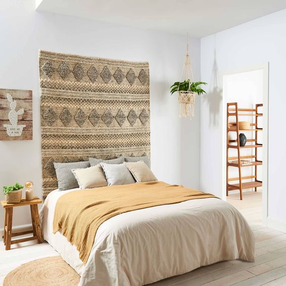 a neutral woven boho rug makes the bedroom feel free-spirited, though all the rest of it is quite neutral
