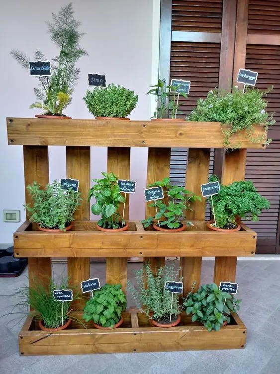 a pallet garden as a plant holder with planters with herbs and chalkboard marks is a cool decoration for outdoors and indoors